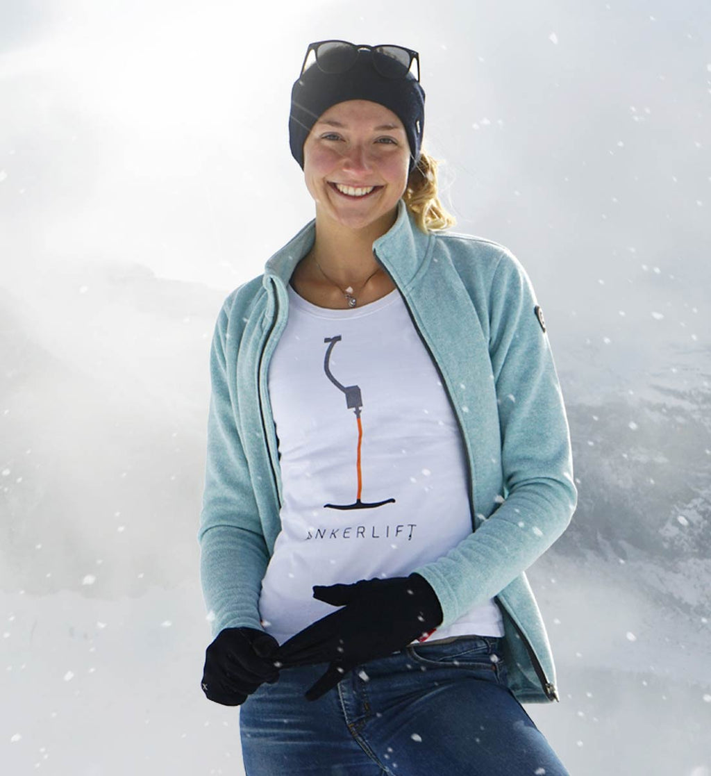 Das originale weiße ANKERLIFT T-Shirt trägt eine Skifahrerin in den verschneiten Bergen.